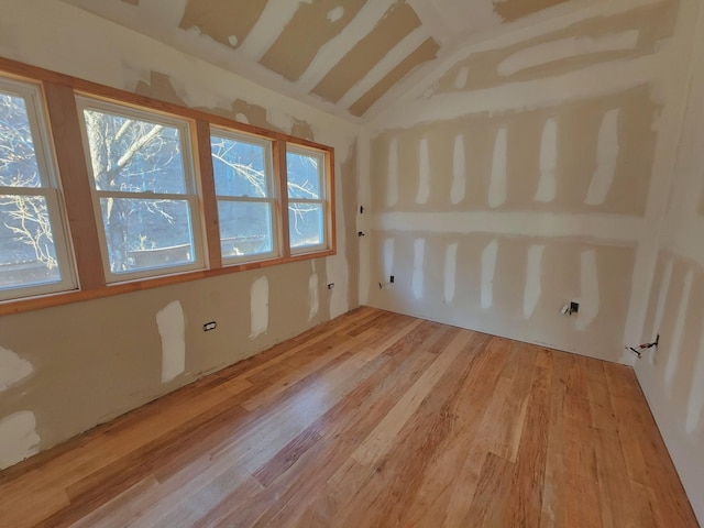 spare room featuring vaulted ceiling and light hardwood / wood-style floors