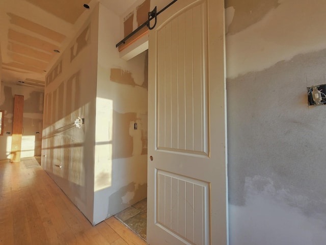 hallway featuring a barn door and light hardwood / wood-style floors