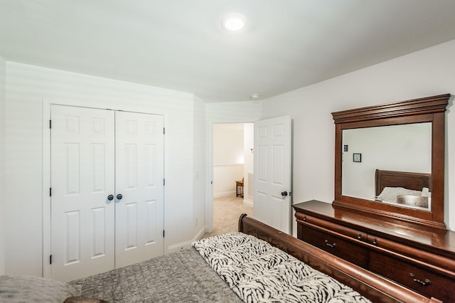 bedroom with light carpet and a closet