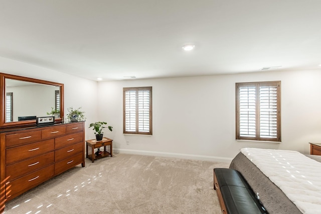 bedroom featuring light carpet and multiple windows