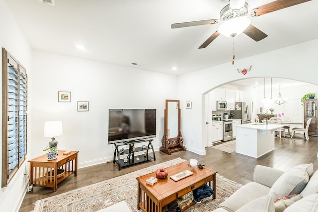 living room featuring dark hardwood / wood-style floors, sink, and ceiling fan with notable chandelier