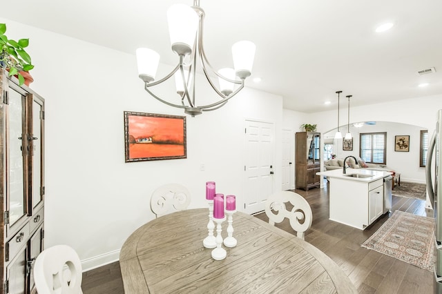 dining space with a chandelier, dark hardwood / wood-style floors, and sink