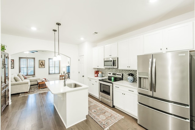 kitchen featuring a center island with sink, white cabinets, sink, ceiling fan, and stainless steel appliances