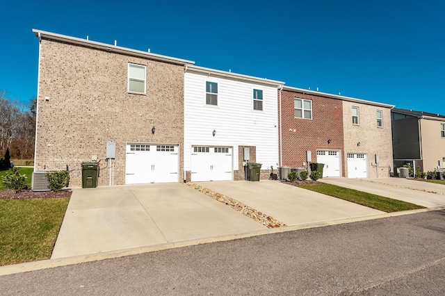 rear view of house featuring cooling unit and a garage