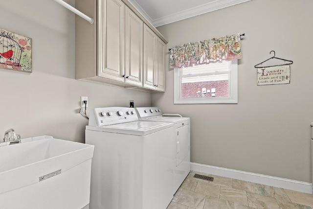 clothes washing area featuring cabinets, washing machine and dryer, crown molding, and sink