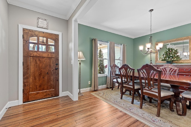 dining room featuring light hardwood / wood-style flooring, ornamental molding, and an inviting chandelier