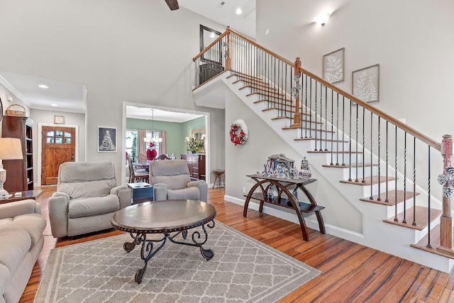 living room featuring a chandelier, wood-type flooring, and a towering ceiling