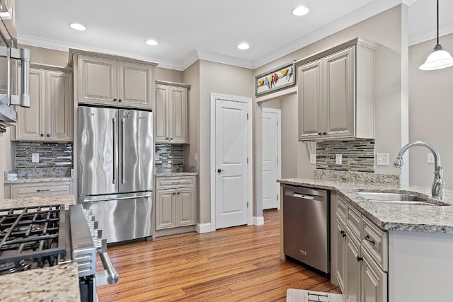 kitchen featuring decorative backsplash, sink, light wood-type flooring, and appliances with stainless steel finishes