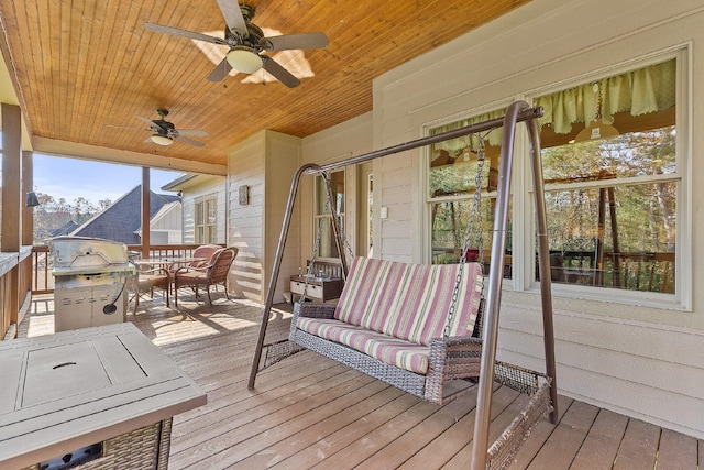 sunroom with ceiling fan and wooden ceiling