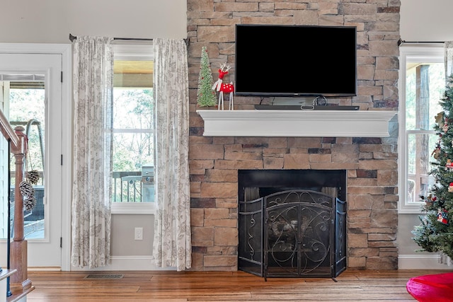 interior details featuring a stone fireplace and hardwood / wood-style floors