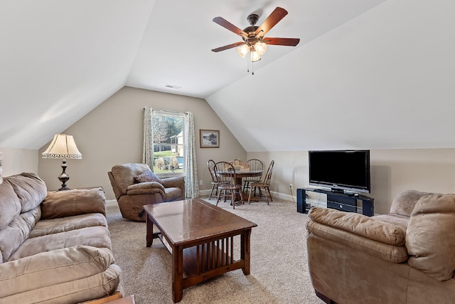 carpeted living room with ceiling fan and vaulted ceiling