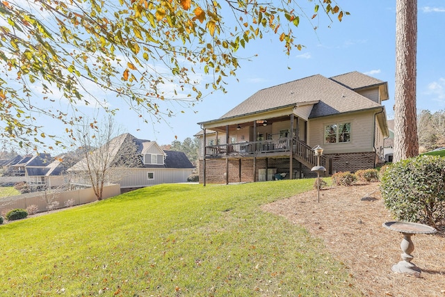 back of house with ceiling fan and a yard