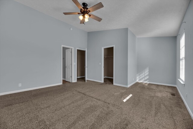 spare room with a textured ceiling, ceiling fan, carpet, and lofted ceiling