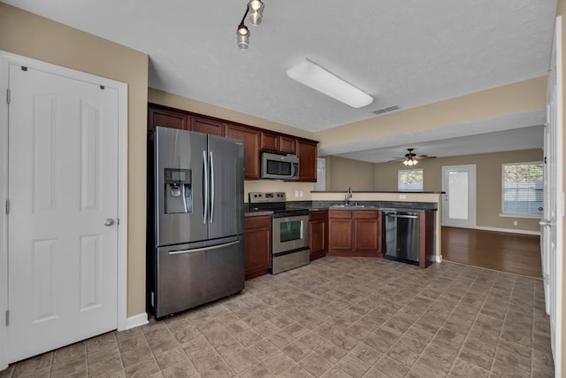 kitchen featuring ceiling fan, sink, kitchen peninsula, and stainless steel appliances