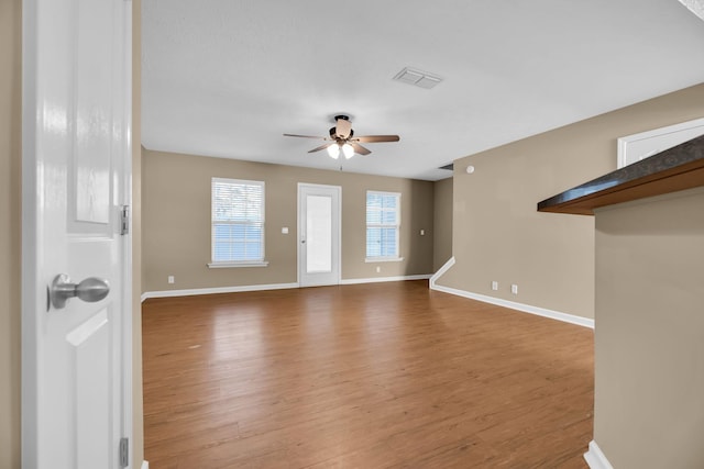 unfurnished living room featuring hardwood / wood-style floors and ceiling fan