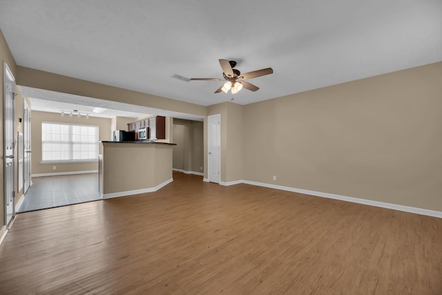 unfurnished living room featuring light hardwood / wood-style flooring and ceiling fan