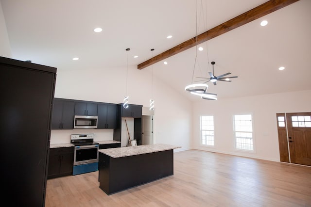 kitchen with a center island, decorative light fixtures, stainless steel appliances, high vaulted ceiling, and beam ceiling