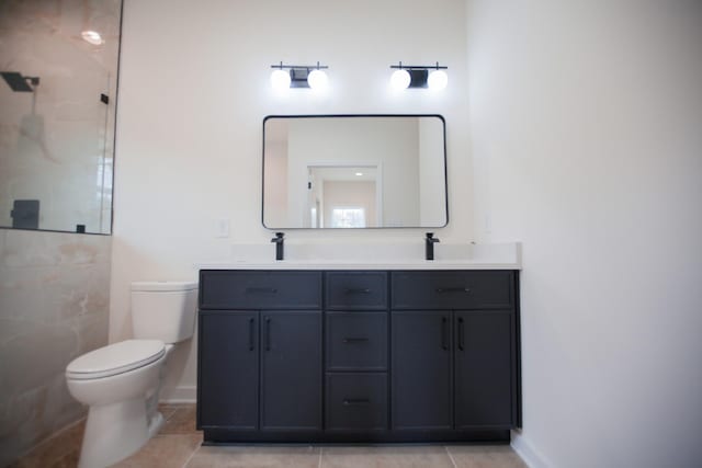 bathroom with toilet, vanity, tile patterned flooring, and a tile shower