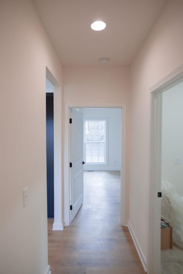 hallway with light hardwood / wood-style floors