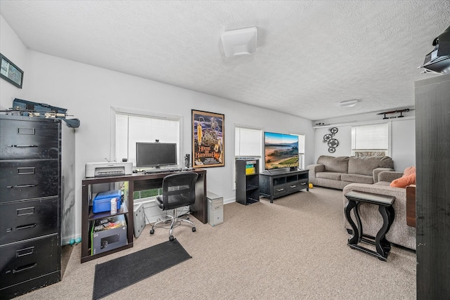 carpeted office space featuring a textured ceiling