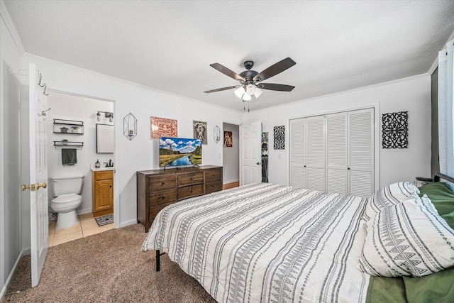 bedroom with light carpet, ceiling fan, ornamental molding, connected bathroom, and a closet