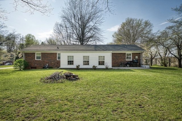 rear view of property with an outdoor fire pit, a patio area, and a lawn