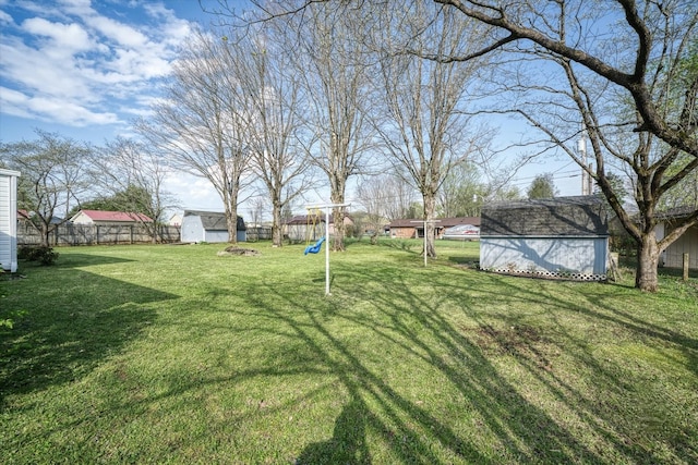 view of yard featuring a storage unit and a playground