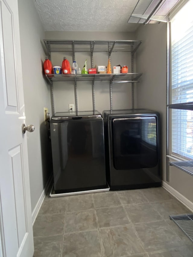 washroom featuring tile patterned flooring, independent washer and dryer, and a textured ceiling