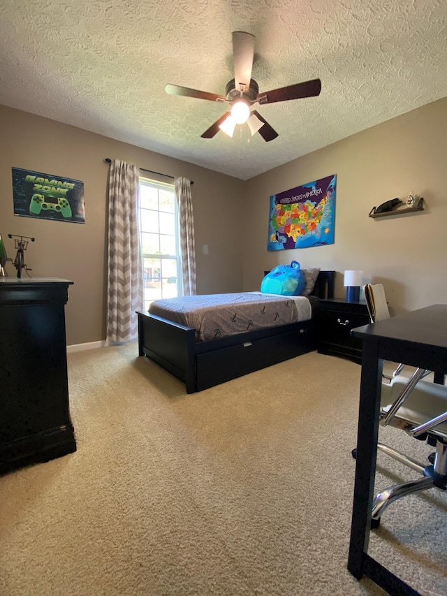 carpeted bedroom featuring ceiling fan and a textured ceiling