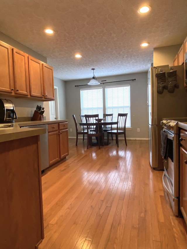 kitchen with dishwasher, light hardwood / wood-style floors, white range oven, and a textured ceiling