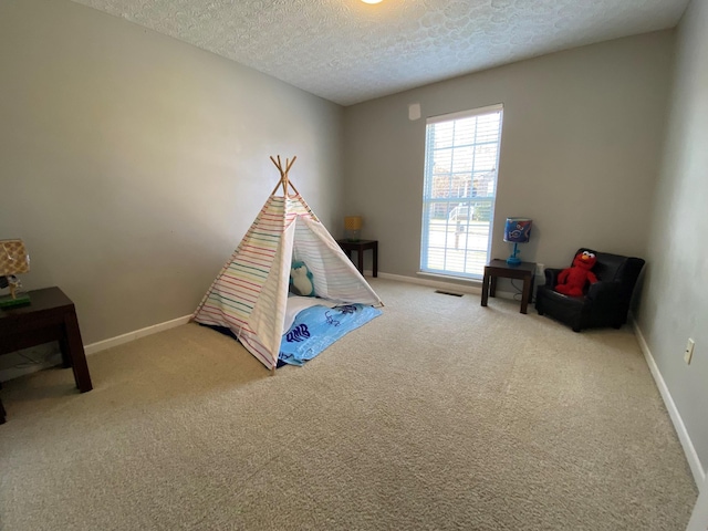 game room featuring a textured ceiling and carpet floors