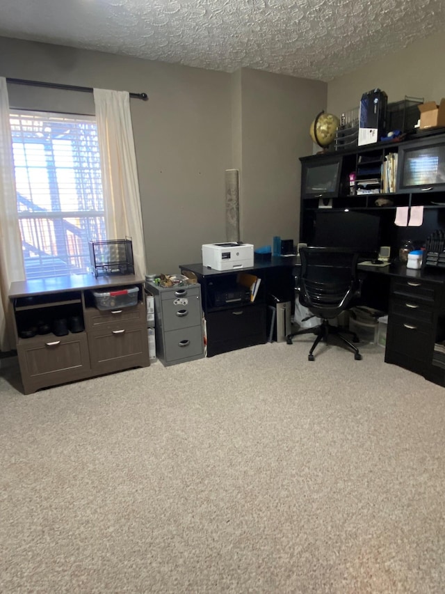 carpeted office space featuring a textured ceiling