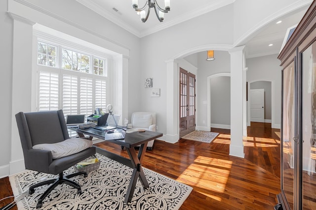 home office featuring an inviting chandelier, dark hardwood / wood-style flooring, decorative columns, crown molding, and a towering ceiling