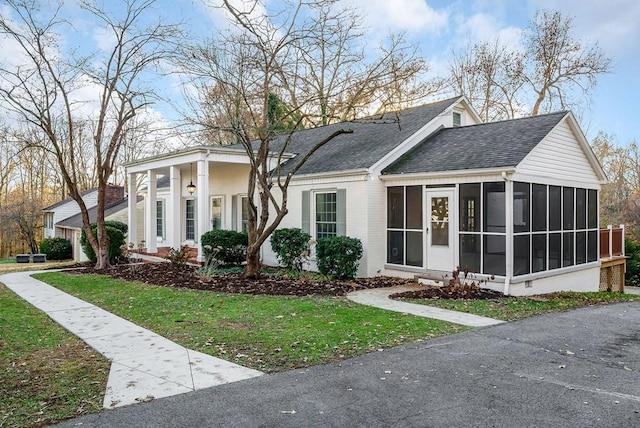 view of front of house featuring a front lawn and a sunroom