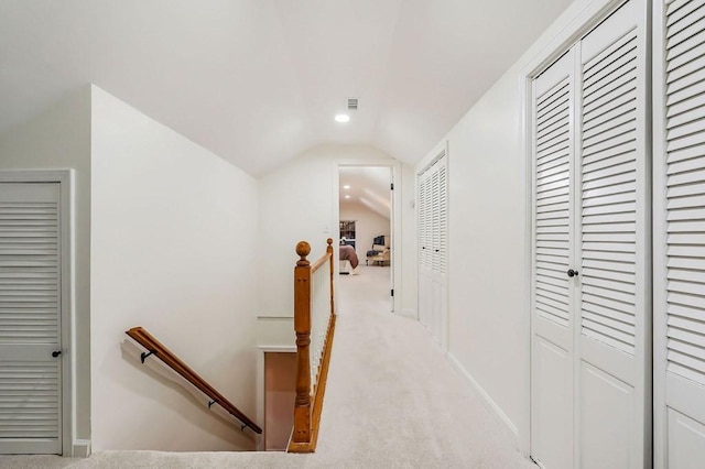 hall with light colored carpet and vaulted ceiling