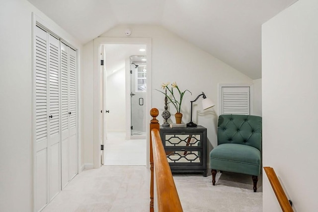 hall with light colored carpet and lofted ceiling