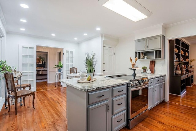 kitchen featuring light hardwood / wood-style flooring, stainless steel electric stove, crown molding, and light stone counters