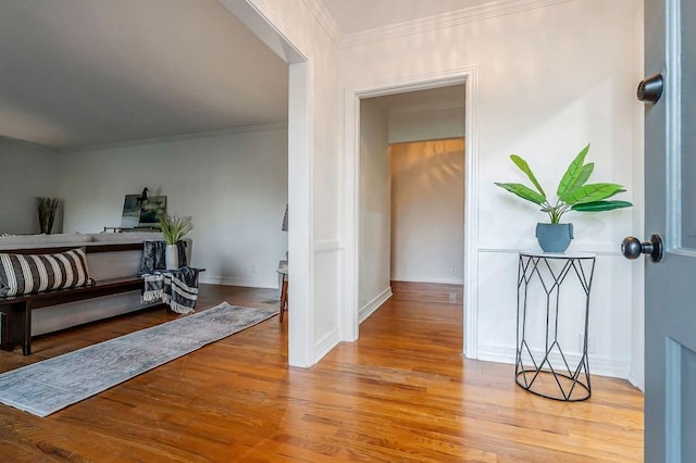 hallway with hardwood / wood-style floors and ornamental molding