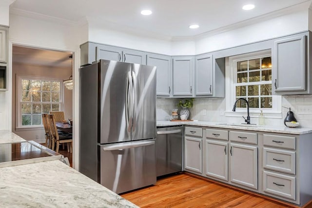 kitchen featuring decorative backsplash, sink, stainless steel appliances, and light wood-type flooring