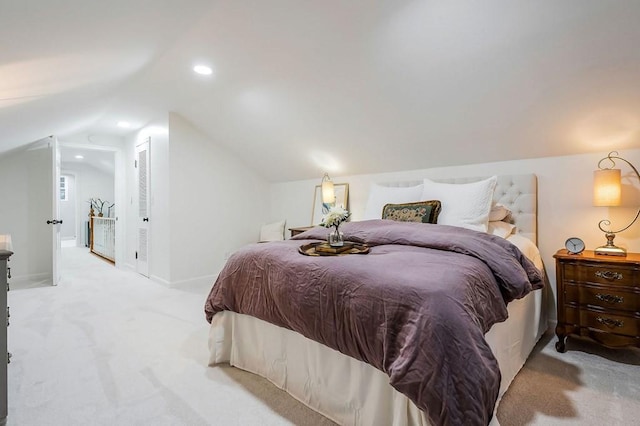 bedroom featuring a closet, light colored carpet, and vaulted ceiling