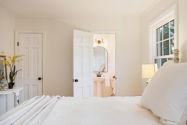 bedroom featuring connected bathroom and crown molding