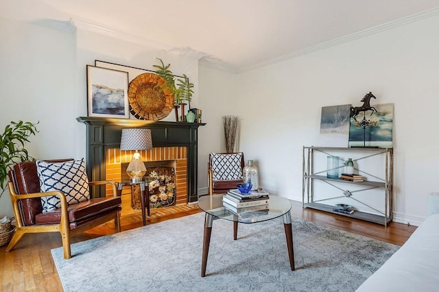 sitting room with a fireplace, hardwood / wood-style flooring, and ornamental molding