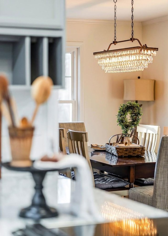 dining space featuring a chandelier and ornamental molding