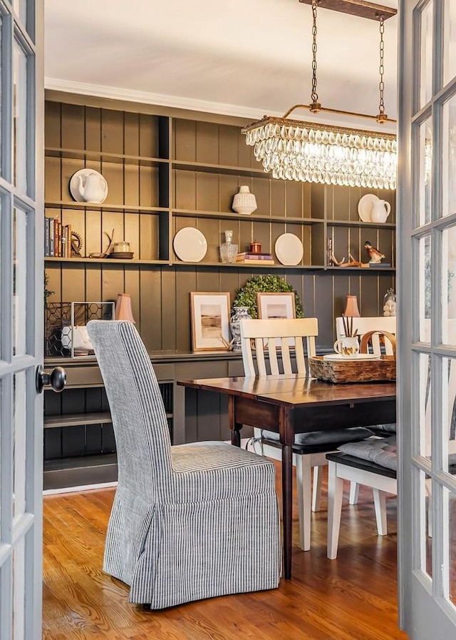 dining area featuring hardwood / wood-style floors, an inviting chandelier, and built in features