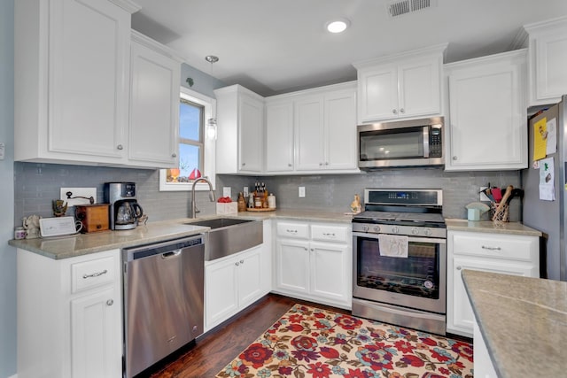 kitchen featuring white cabinets, pendant lighting, sink, and stainless steel appliances