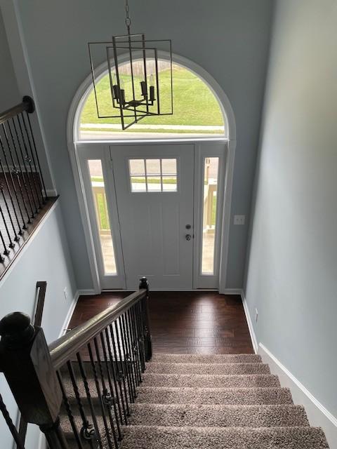 entryway with a notable chandelier and dark hardwood / wood-style flooring