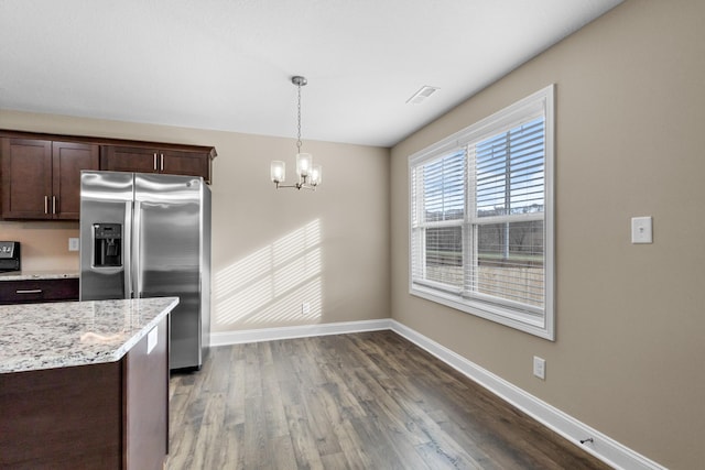 kitchen with pendant lighting, dark wood-type flooring, an inviting chandelier, dark brown cabinets, and stainless steel fridge with ice dispenser