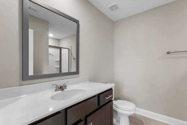 bathroom featuring tile patterned floors, vanity, toilet, and a shower with door