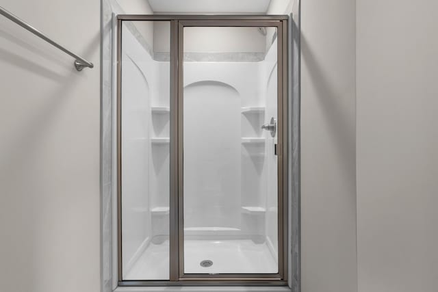 bathroom featuring a shower with door