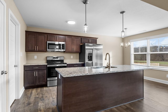 kitchen featuring pendant lighting, sink, stainless steel appliances, and dark wood-type flooring